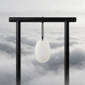 Jade pendant hanging on wooden stand with ink wash landscape