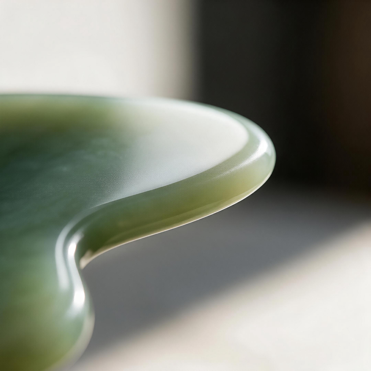 Close-up of smooth jade gua sha stone with polished edges