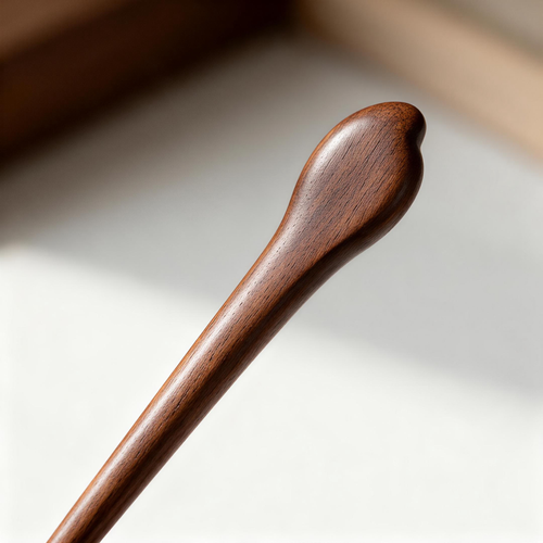 Close-up of polished wooden hair stick with natural grain texture